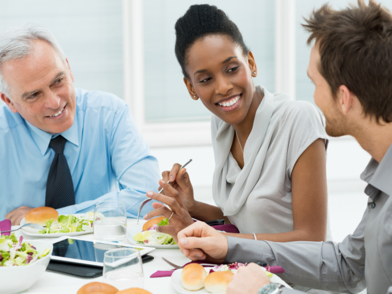 two men and a woman having lunch in a happy mood